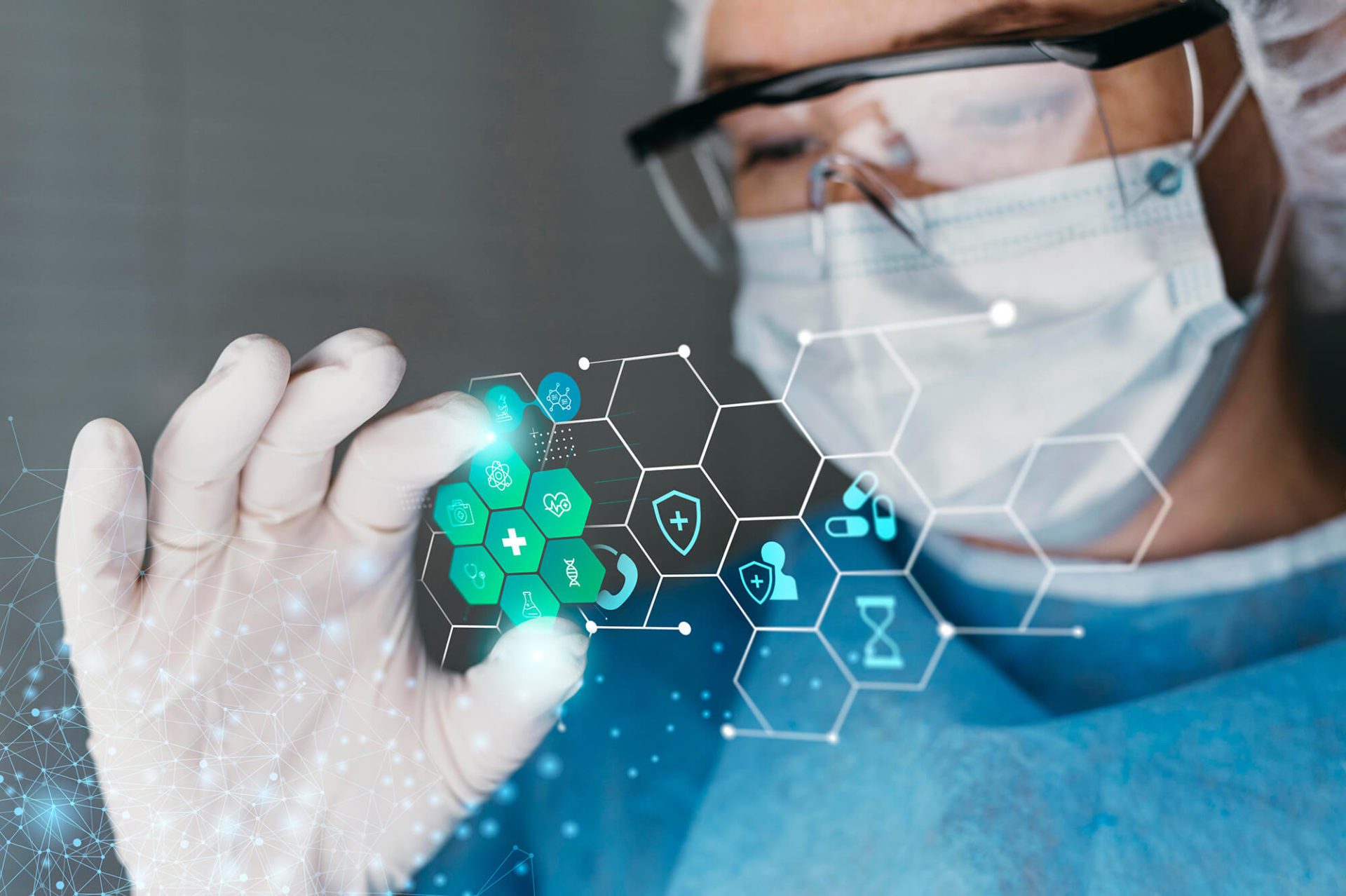 A scientist wearing gloves and a surgical mask interacts with a futuristic holographic interface showing molecular and chemical structures.