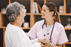 A smiling healthcare professional shares a joyful moment with an elderly woman during a consultation.